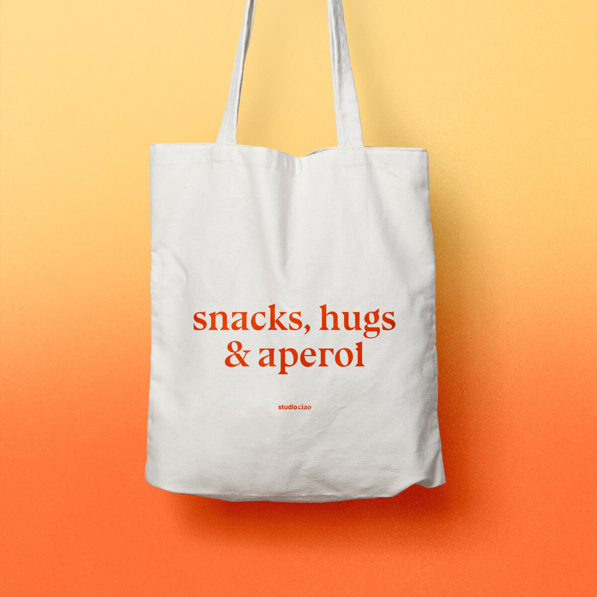 Snacks, hugs & Aperol Jutebeutel. Heller Stoffbeutel mit rot-orangenem Aufdruck.